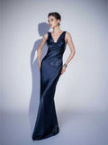 Woman wearing a navy blue evening gown against a light gray background
